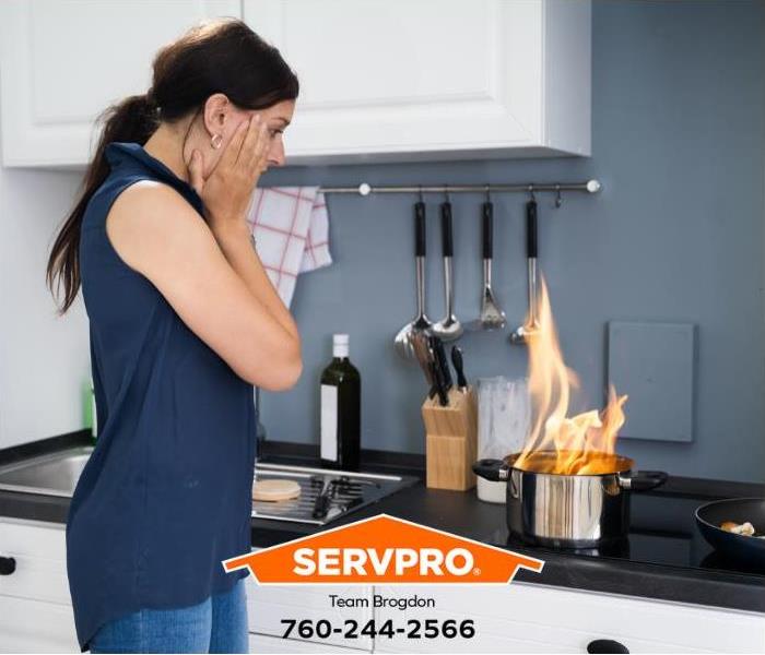 Flames fly out of a pan while a person is cooking at home.